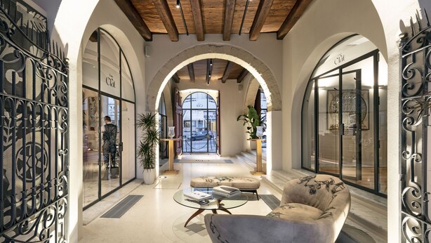 An interior with arched ceilings, a seating area with a sofa and coffee table, and a view through a large window. - Casa Clàt – Boutique Hotel (Cagliari)