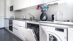 A modern kitchen with white cabinetry, a built-in dishwasher, and a microwave. - Keluak Apartment, Wifi, Balcony !new! (Lisboa)