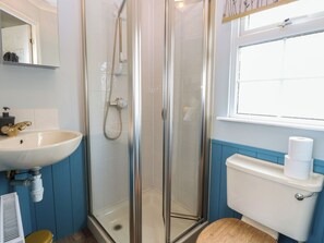A bathroom with a glass-enclosed shower, a sink, and a toilet.