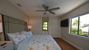 A bedroom with a bed, a ceiling fan, a window, and a TV mounted on the wall. - Canal View 2BR Retreat, Near Bonita Beach! Sleeps 4 (Bonita Springs)