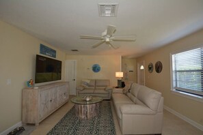 A living room with a ceiling fan, a television, a sofa, a coffee table, and a patterned rug. - Canal View 2BR Retreat, Near Bonita Beach! Sleeps 4 (Bonita Springs)