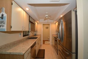 A compact kitchen with a refrigerator, sink, and cabinets. - Canal View 2BR Retreat, Near Bonita Beach! Sleeps 4 (Bonita Springs)