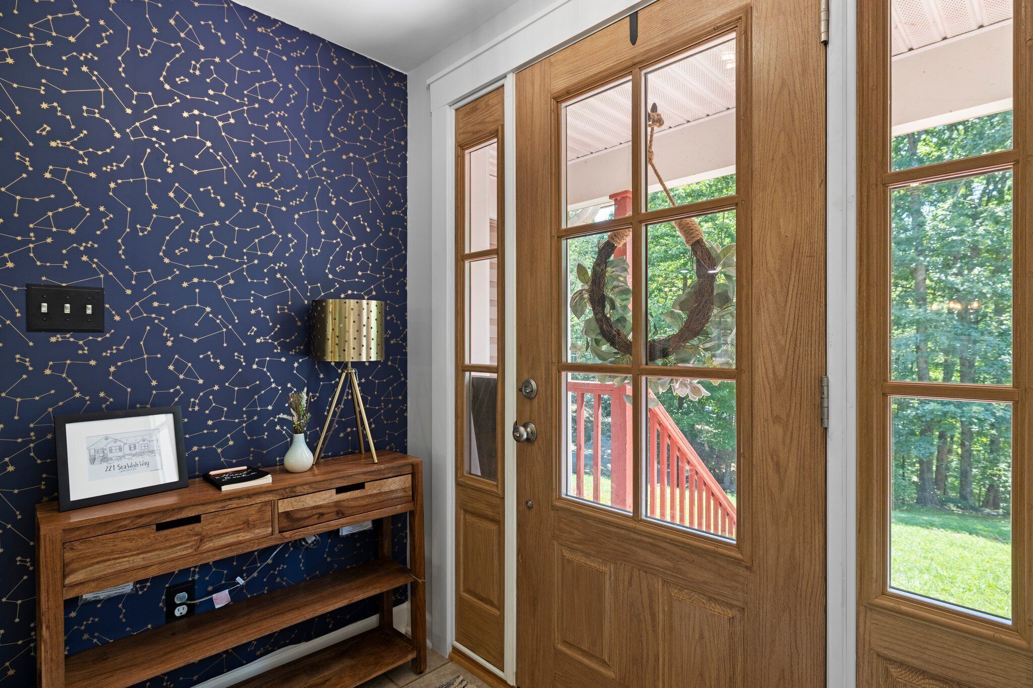A wooden door with glass panels, a wreath hanging on the right side, and a starry wall pattern.