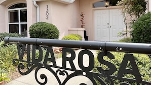 A house with a number '1302' on the wall, a white door, and a sign with 'VIA ROSA' in front. - Private Heated Pool and Hottub , Pet Friendly, New Golf Cart , Close to shopping (Lady Lake)