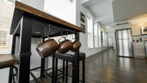 A modern kitchen with a wooden table and hanging copper pots. - 725- Big 2 bedroom/king beds/Corner Unit/ + parking (Milwaukee)