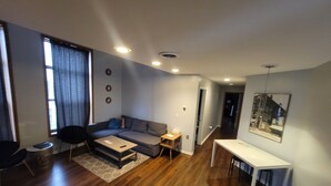 Ein modernes Wohnzimmer mit einer Couch, einem Couchtisch und einem Essbereich mit Tisch und Stühlen.