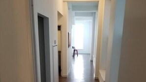 A narrow hallway with wooden flooring and white walls. - 325- Big Corner condo w/2 king bedrooms/Free parking (Milwaukee)
