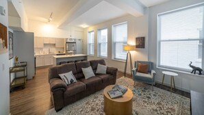 A modern apartment with a living room, kitchen, and dining area.