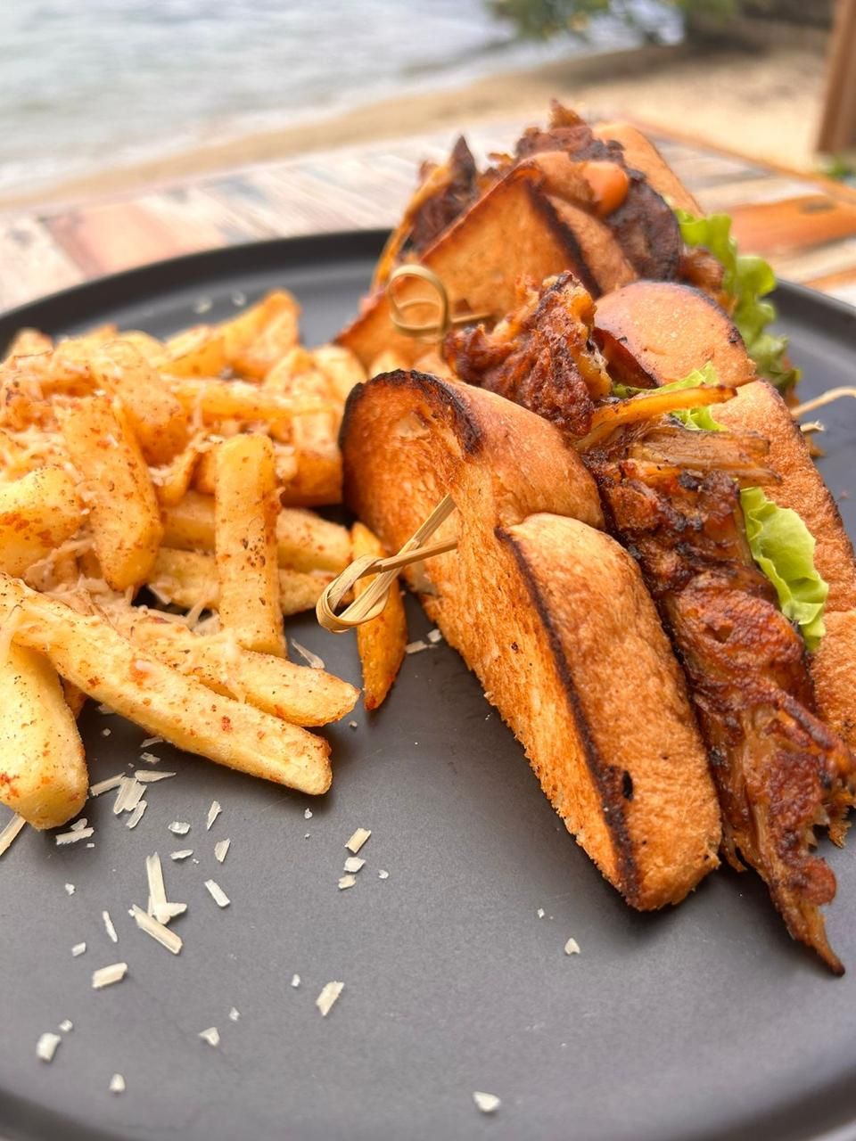 Um prato com sanduíche, batatas fritas e uma salada.