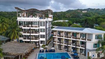Un resort con piscina, varias plantas y zona de playa.