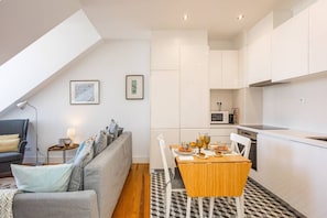 A modern apartment with a dining area, kitchen, and living space.