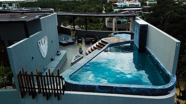 A rooftop pool with a view of the surrounding buildings and greenery. - LUXURIOUS 2 STORY PH / PREMIUM AREA / PRIVATE PLUNGE POOL / HEART OF ALDEA ZAMA (Q.R.)