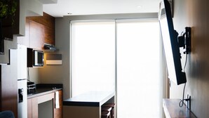 A modern kitchen with a built-in microwave, a coffee machine, and a large sliding glass door leading to a balcony. - LUXURIOUS 2 STORY PH / PREMIUM AREA / PRIVATE PLUNGE POOL / HEART OF ALDEA ZAMA (Q.R.)