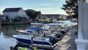 A marina with boats docked along a wooden pier, surrounded by residential buildings. - Charming Waterfront Retreat with pool & short stroll to beach! (Ocean City)