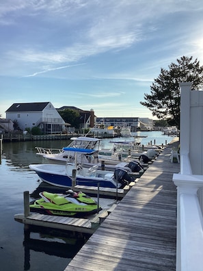 A marina with boats docked along a wooden pier, surrounded by residential buildings. - Charming Waterfront Retreat with pool & short stroll to beach! (Ocean City)