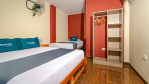 A hotel room with two beds, a wardrobe, and a fan. - Hospedaje Muñoz (Ica)