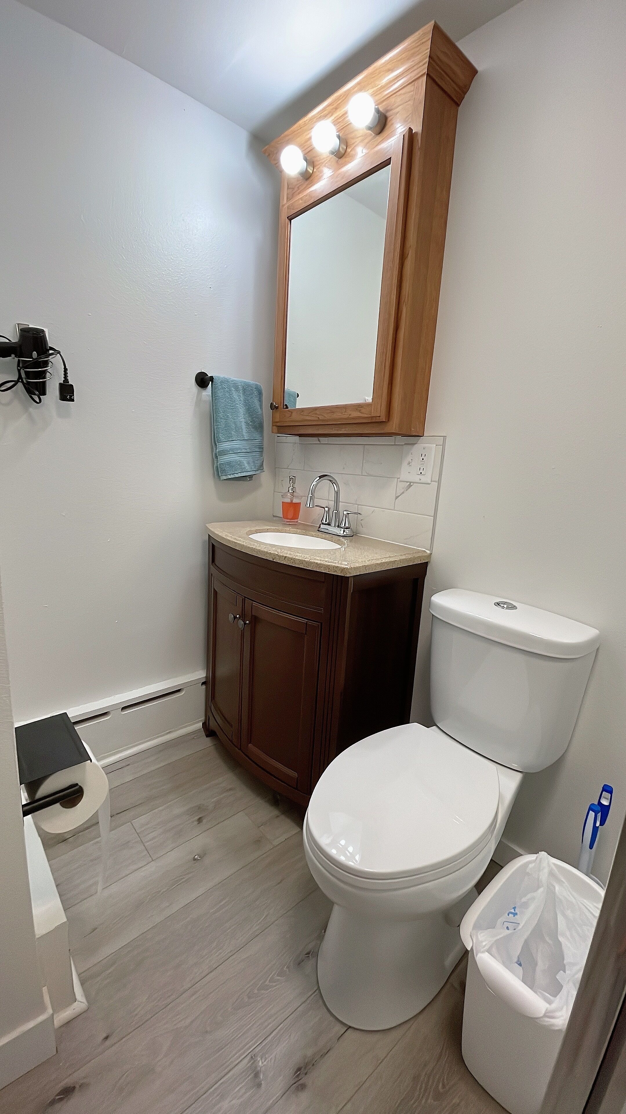 Ein Badezimmer mit Waschtisch, Spüle, Spiegel und Toilette.