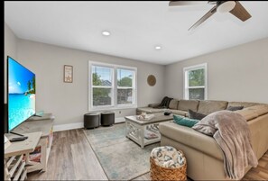 Relax in this stylish living room with a large flat-screen TV, comfortable sofa, and coffee table.