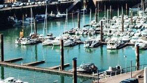 A marina with numerous boats docked, a bridge, and buildings in the background. - La Tour Aux Crabes (Dieppe)