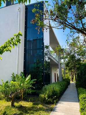 A modern building with a glass facade, surrounded by a well-maintained garden and a paved walkway. - Celeste Bella Luxury Hotel & Spa (Bodrum)
