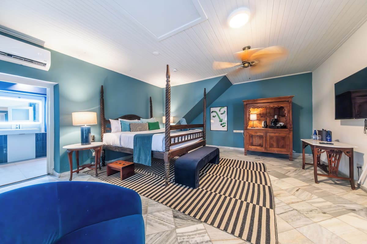 A bedroom with a bed, bedside table, lamp, and a ceiling fan.