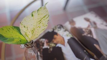 A glass vase with a leaf and a magazine.