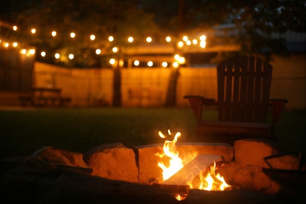 Private fire pit with string lights — cozy evenings under the forest canopy.
