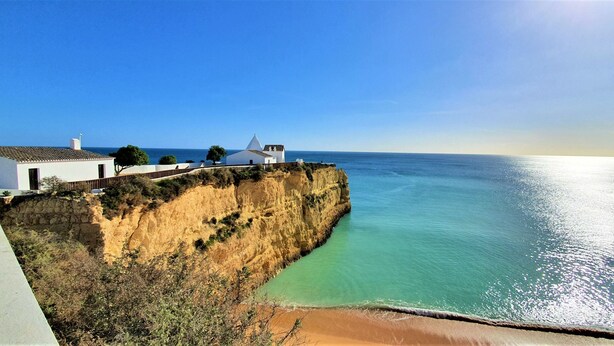 A coastal cliff with a white building featuring a conical roof, overlooking a clear blue sea. - The Algarvean Oasis with Pool by LovelyStay (Alporchinhos)