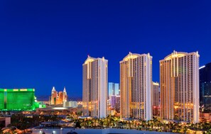 A high-rise hotel with multiple floors, a prominent casino in the background, and a well-lit urban skyline. - Jet Luxury Elite at The Signature (Las Vegas)