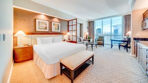 A hotel room with a large bed, a bench, a desk, and a view of the city. - Jet Luxury Elite at The Signature (Las Vegas)