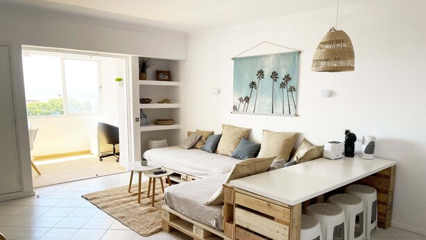 Une chambre à coucher moderne et minimaliste, dotée d’un grand lit, d’un bureau en bois et d’un coin repas.
