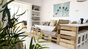 Une chambre à coucher au style minimaliste, avec un lit, une petite table et un banc en bois.