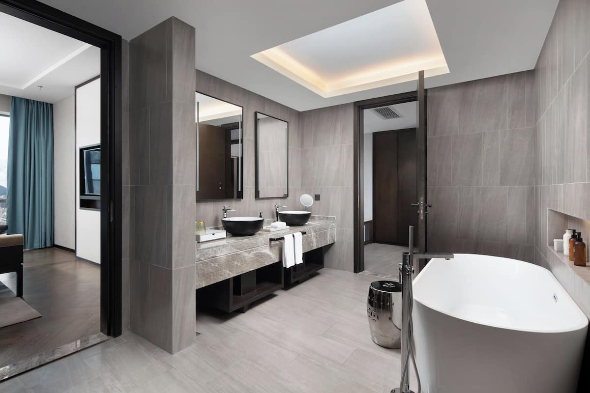 Un baño moderno con una bañera independiente, un lavamanos doble con un espejo grande y una zona de ducha.