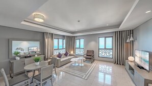 A modern living room with a dining area, large windows, and a television. - Wyndham Residences The Palm (Dubai)