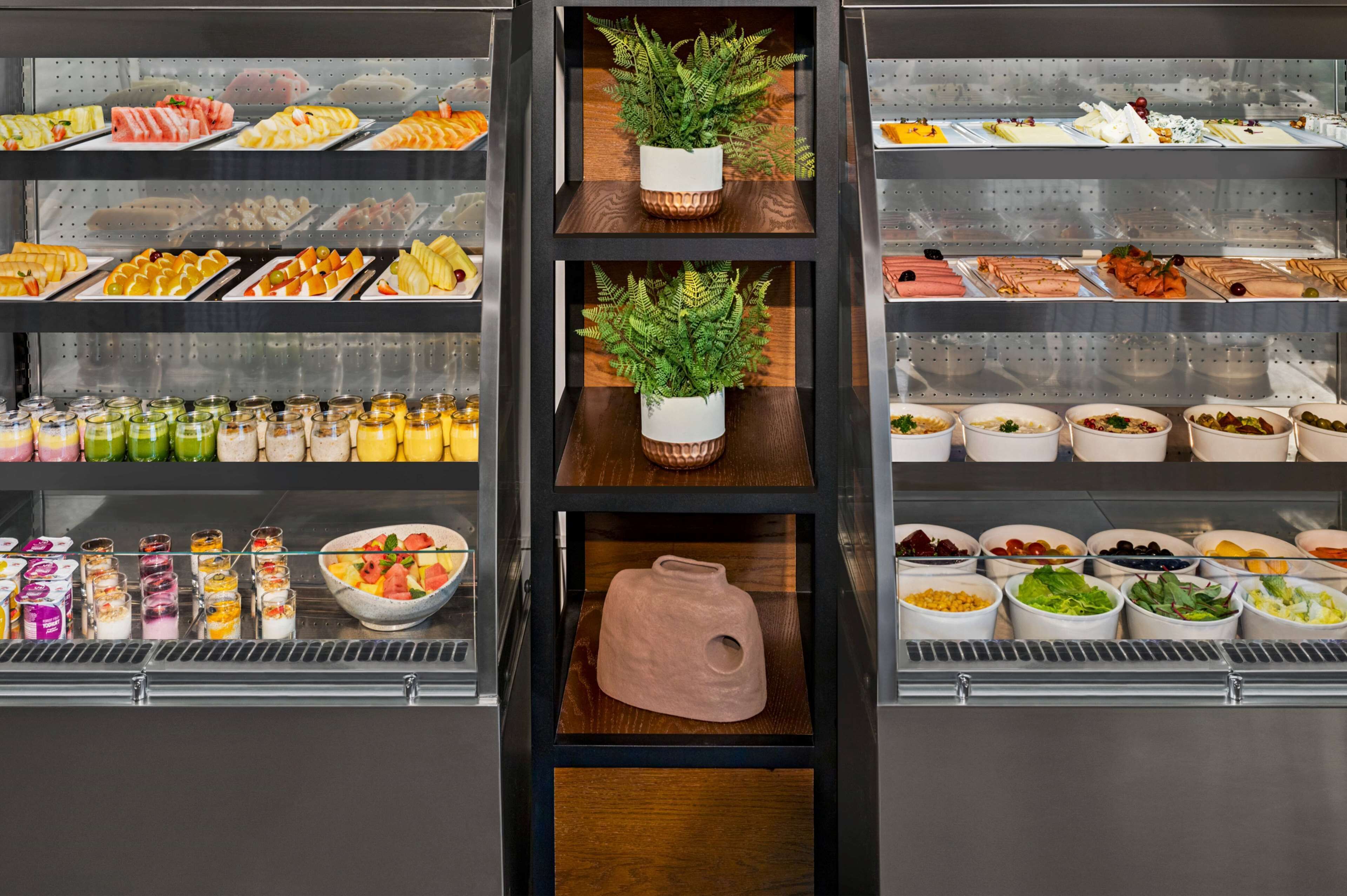 A buffet with various food options, including fruits, vegetables, and prepared dishes.