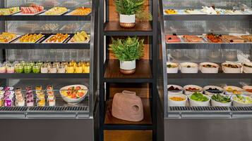 A buffet with various food options, including fruits, vegetables, and prepared dishes.