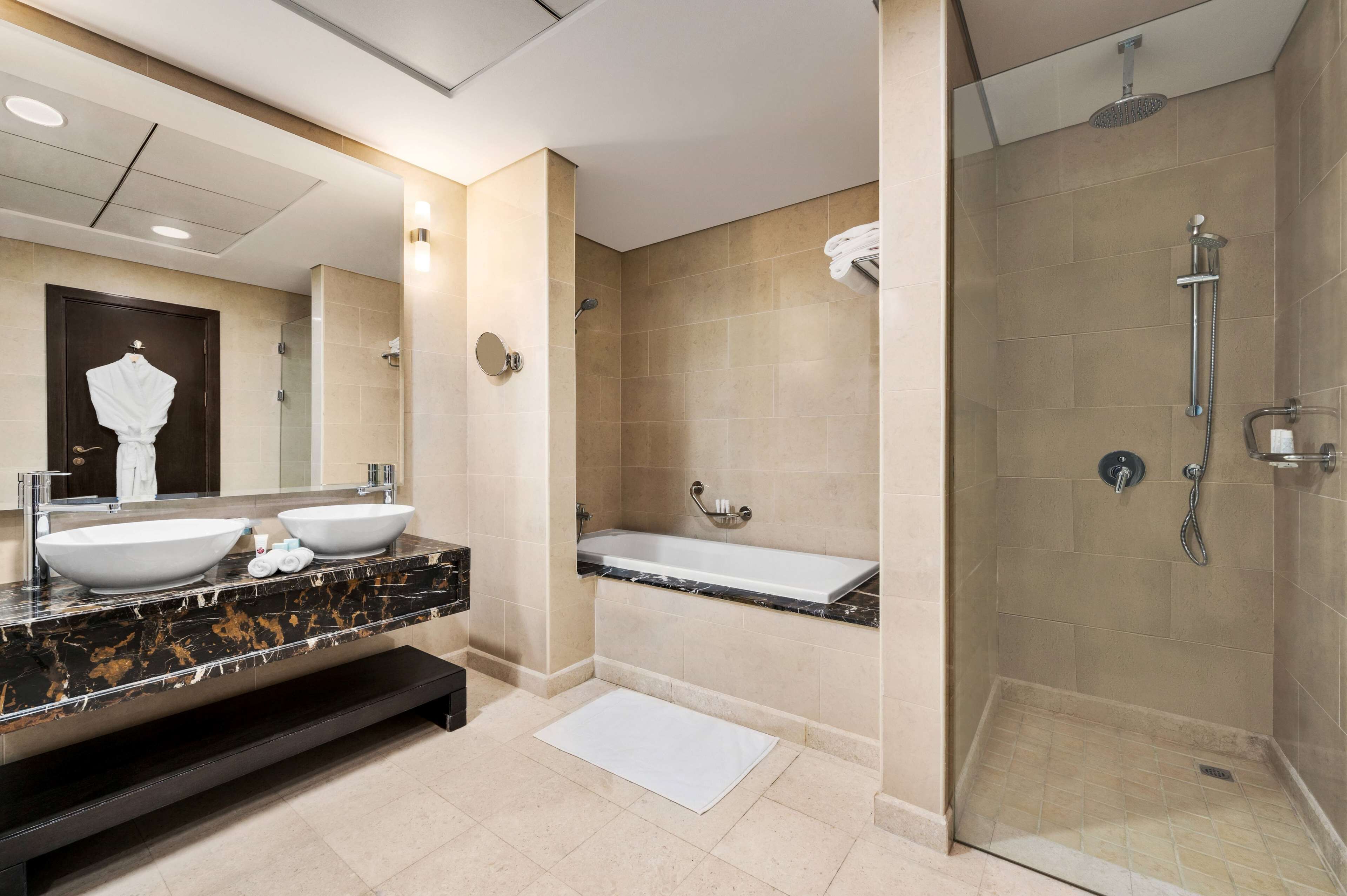 Un baño moderno con dos lavamanos, una bañera e hidromasaje.
