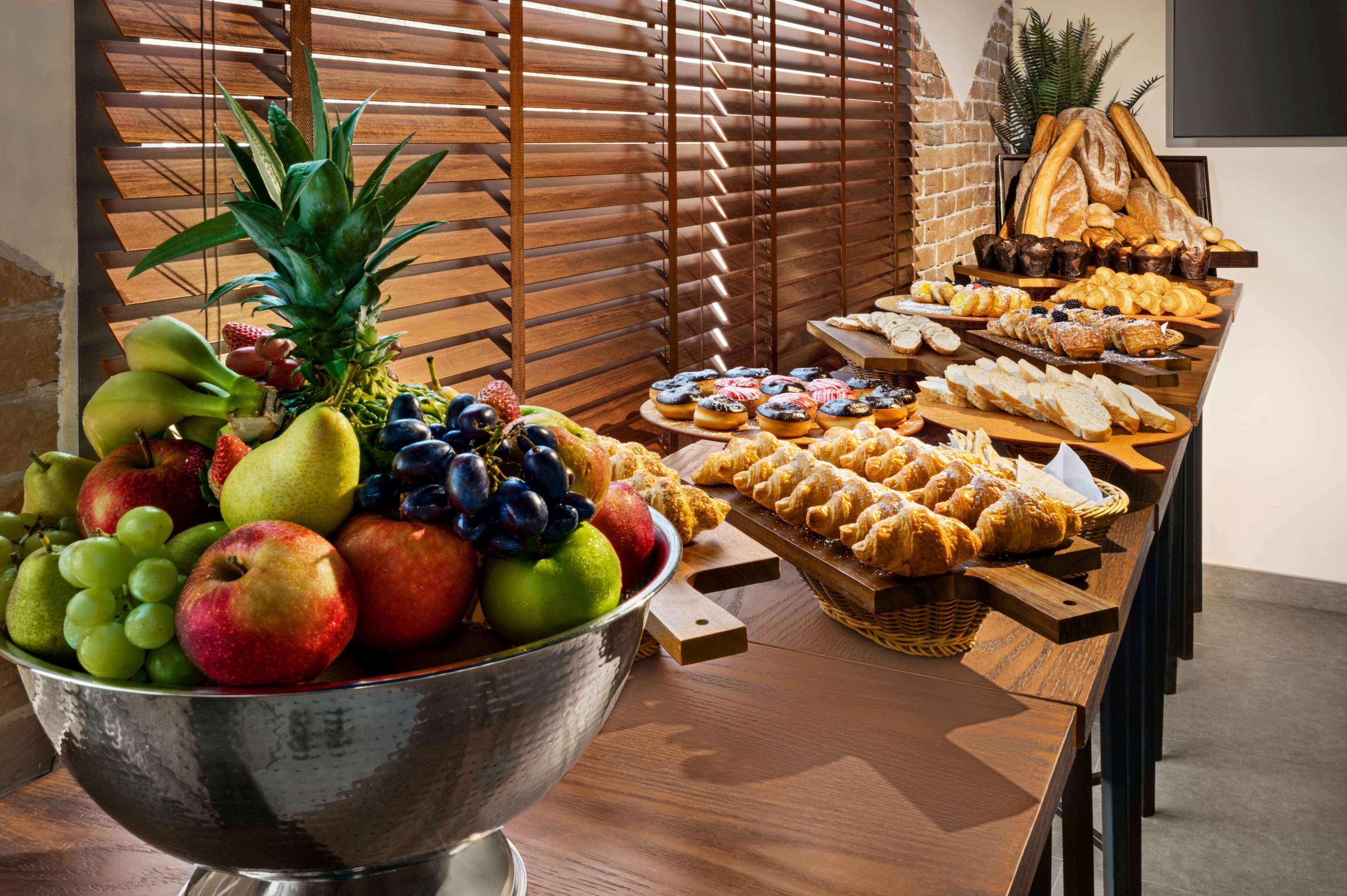 A buffet table with a variety of fruits and pastries.