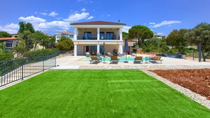 A two-story house with a swimming pool and outdoor seating area. - Villa MAGNIFICA with pool (Pinezići)