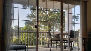 Ein Zimmer mit einer Schiebetür und Zugang zu einer Terrasse mit Tisch und Stühlen.