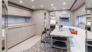 Un interior moderno con zona de comedor, sofá blanco y alfombra con estampado de cebra.