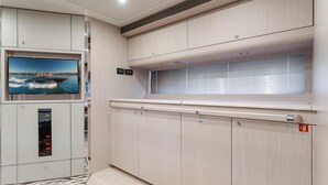 Una cocina moderna con televisor integrado, una ventana con persianas y un panel de control debajo del televisor.