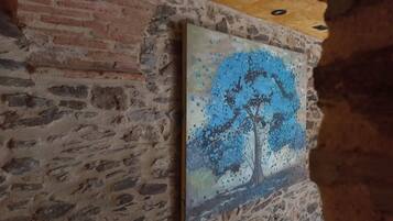 Een schilderij van een boom op een structuurwand.