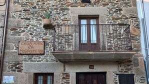 Un bâtiment rustique en pierre sur lequel est apposée une enseigne indiquant : « CASA RURAL LA MORAQUINTANA ».