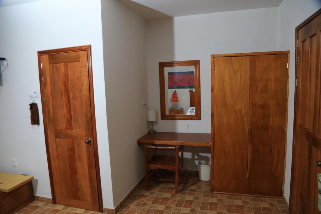 A hallway with wooden doors, a small desk with a chair, and a tiled floor.