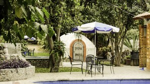 Uma área de piscina com uma estrutura em forma de cúpula, assentos externos e uma placa indicando 'El Molino Hotel'.