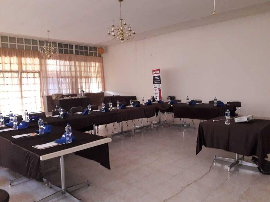 A conference room with tables set up for a meeting, equipped with water bottles and nameplates.