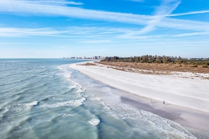 A beach with a clear view of the ocean and a distant city skyline. - Cozy 1-bedroom condo a short walk to Siesta Key Beach (Siesta Key)