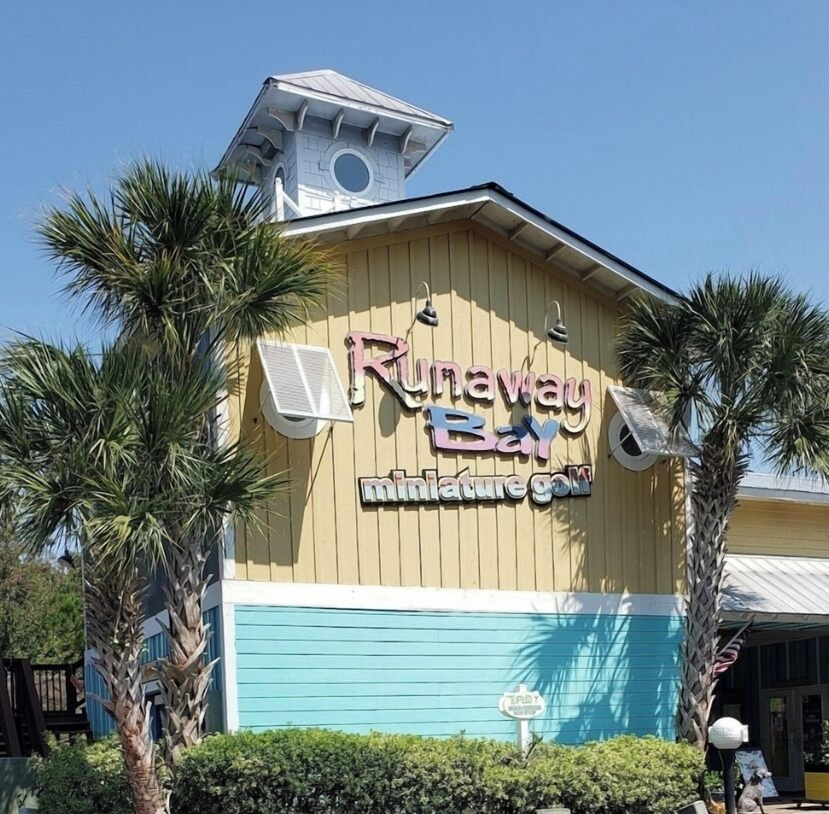 A building with a sign reading "Runaway Bay Miniature Golf."