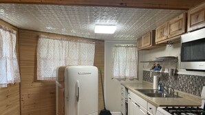 A compact kitchen with a refrigerator, stove, microwave, and sink. - Lakeview  pet friendly (Warsaw)